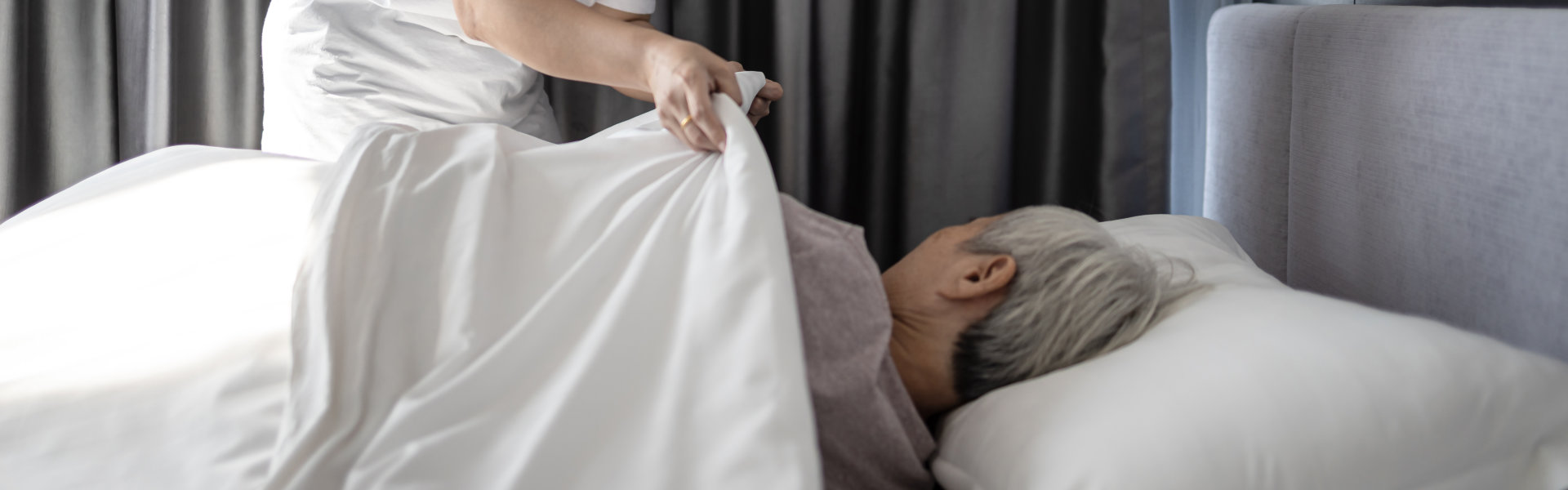 caregiver covering the elderly a blanket