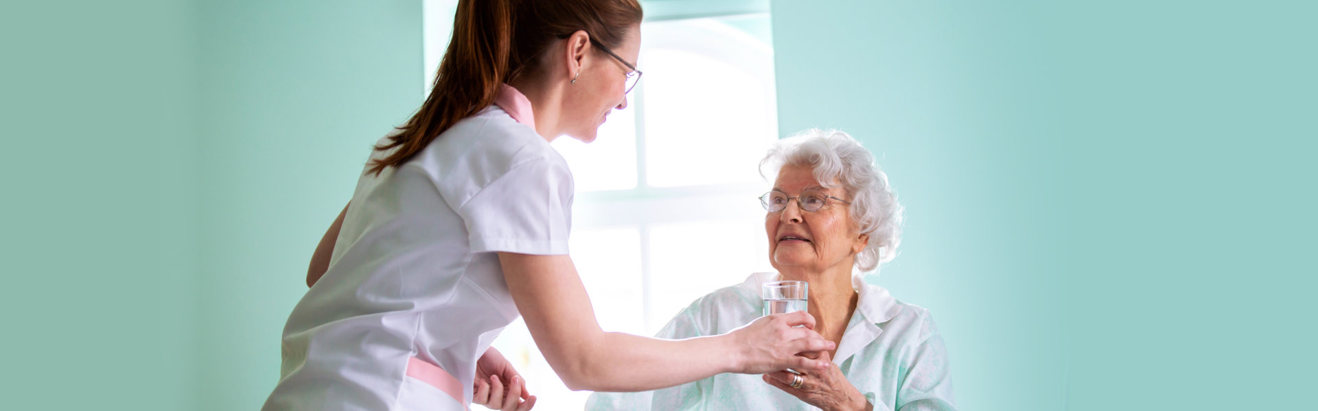 nurse giving medicine to elderly